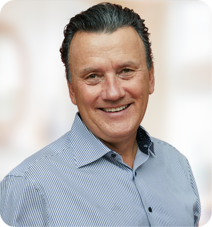 Portrait of Richard Robbins smiling in a striped shirt