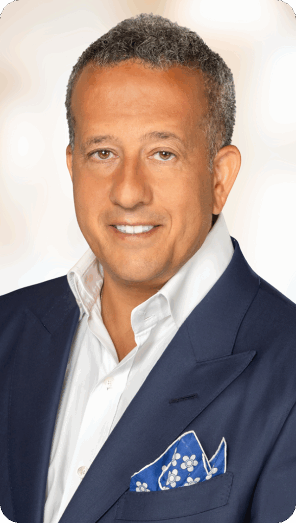 Portrait of a smiling man in a navy suit with a blue floral pocket square
