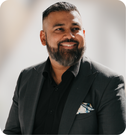 Portrait of a smiling man with a beard wearing a dark suit